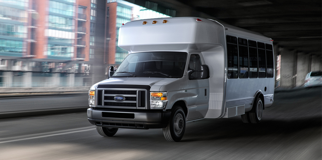 Ford E-series shuttle bus driving down the road