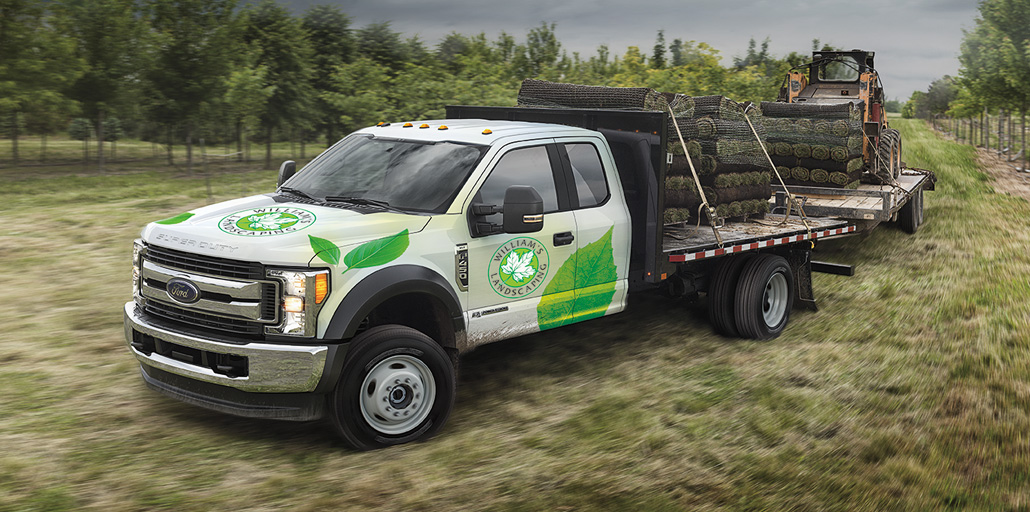 Ford Super Duty pickup with company logo and information printed on the doors.